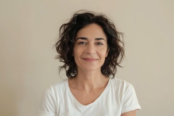Fototapeta premium A woman in a white t-shirt smiling at the camera. Suitable for various projects.