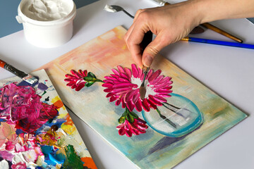 acrylic painting of flowers with palette knife and acrylic paints, artist's hand. Top view