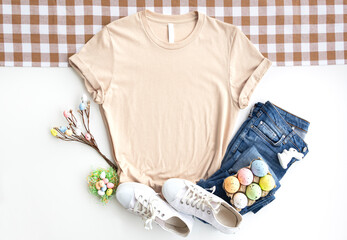 Soft Cream womans cotton Tshirt mockup with easter eggs , jeans, sneakers on white background....