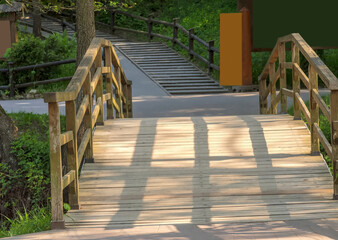 Mały drewniany mostek tworzący wiosną niepowtarzalną atmosferę w parku wśród drzew.Piękny...