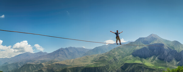 Man walking on rope in high mountains. Rope walk - obrazy, fototapety, plakaty