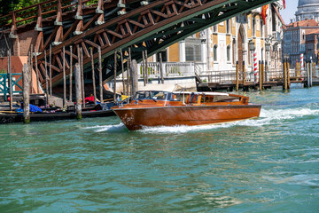 Wooden Taxi Boat Speeding Under Venice's Bridge