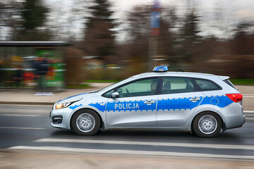 Radiowóz polskiej policji na sygnałach alarmowo szybko jedzie przez miasto na interwencję.
