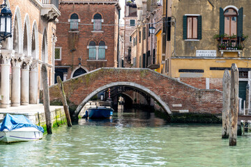 Fototapeta na wymiar Historic Venetian Bridge Over Quiet Canal in Venice, Italy