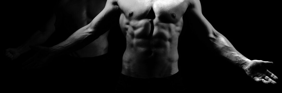 Muscular man body on a black background. Naked strong body, nude male. Sexy naked torso, six pack abs.