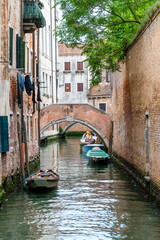 Quiet Canal in Venice with Arching Bridge and Boats