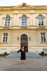 Beautiful university graduate in a black gown. The happy student successfully completed university...