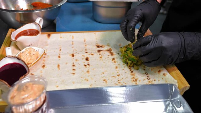 Chef Paovar in kitchen of restaurant collects assorted on plate of pita bread with pickles, cabbage, garlic, restaurant menu Assorted pickled or pickled vegetables.