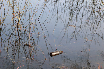 Śmieci wrzucone do rzeki - zanieczyszczenie środowiska.  © FotoDax