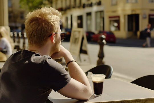 Man sitting at table with cup of coffee outdoors