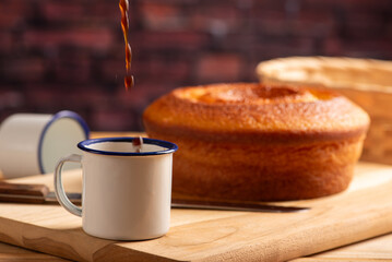 Orange cake and cup of coffee, beautiful orange cake and a cup of coffee and accessories on rustic wooden surface, dark background, selective focus.