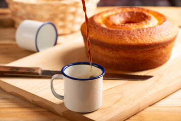 Orange cake and cup of coffee, beautiful orange cake and a cup of coffee and accessories on rustic wooden surface, dark background, selective focus.