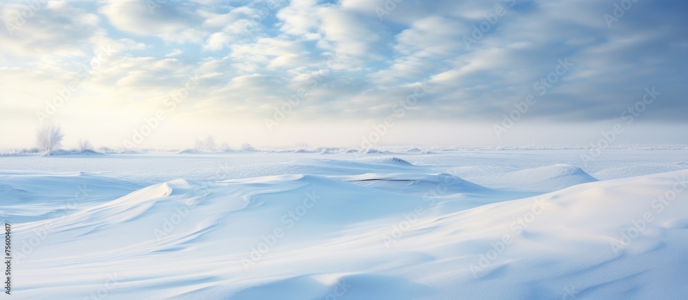 Sticker The sun shines through the cumulus clouds over a snowy field, creating a beautiful natural landscape with blue skies and a fluid horizon