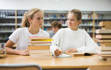 Fototapeta premium Two friends are studying in the school library. Exam preparation