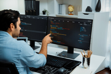 Concentrating in smart IT developer working software development coding on two pc screen, creating...