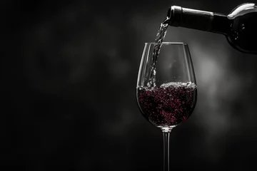 Fotobehang Wine poured into a glass on a black background © Александр Лобач