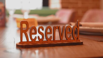 Elegant Reserved wooden sign placed on table in gourmet restaurant creates refined and exclusive atmosphere