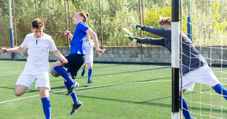 Young football players fighting for ball in goalmouth zone