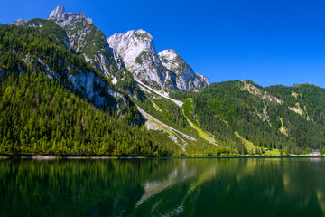 Transparent water of Lake Gosausee. Reflection of mountains in the clear water of Lake Gosausee on Salzkammergut, Austria. Tourism in Europe.