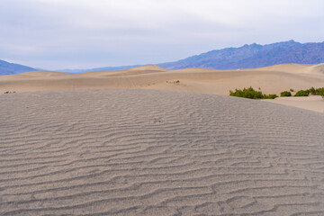 Large sand dunes in death valley national park on a cloudy, overcast day.