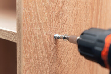 Assembling furniture, tightening confirmat with a screwdriver