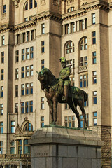 Obraz premium Equestrian statue in front of a historic building with intricate architecture in Liverpool, UK.