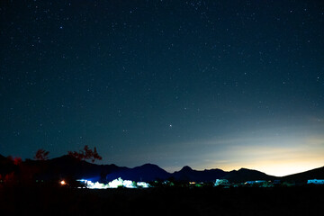 Campfires and stars while camping in Mojave Desert. Light pollution seen from Las Vegas.