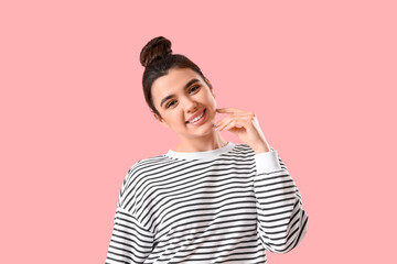 Pretty smiling young woman on pink background