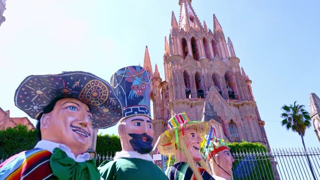 Giant puppets also known as mojigangas in front of the Parroquia of San Miguel Arc&aacute;ngel in plaza Allende at the morning, city of San Miguel De Allende, Mexico.  Magic town