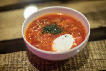 Borscht with sour cream. Greens in soup. Russian borscht.