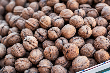 Organic walnuts on market stall in a park, close up, details