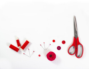 Red sewing accessories on white background.