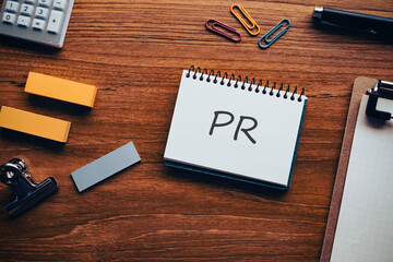 There is notebook with the word PR. It is an abbreviation for public relations as eye-catching...