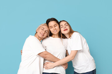 Portrait of hugging women on blue background. Women history month