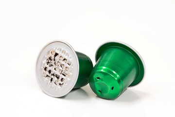 Green used aluminum coffee pods single use cups, isolated on a white background with copy space.	