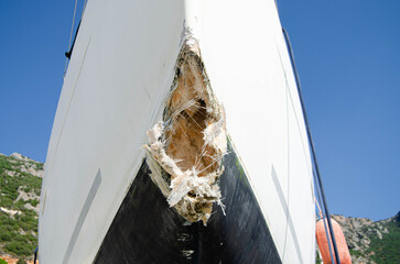 The collision-damaged bow of the fiberglass sailboat.