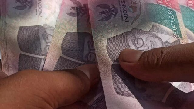counting rupiah money by hand