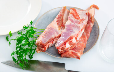 Fresh raw pork ribs with parsley on wooden table. Cooking food