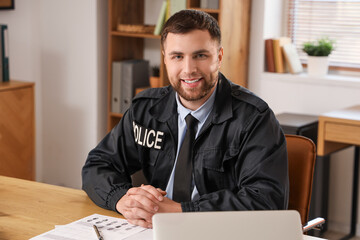 Male police officer sitting in office
