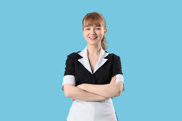 Young chambermaid on blue background