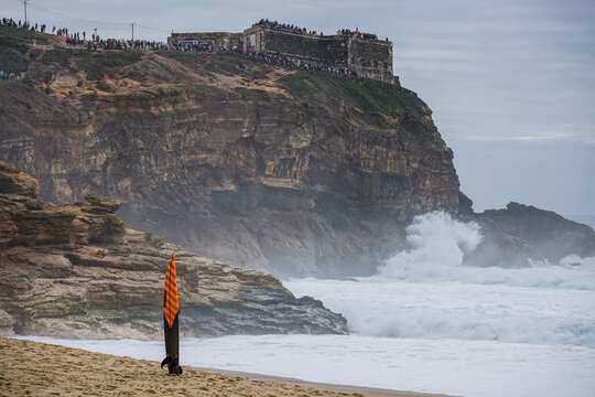 crowd of spectators watching the big wave surfers on the famous cliffs at the lighthouse at Nazar&eacute; Praia do Norte