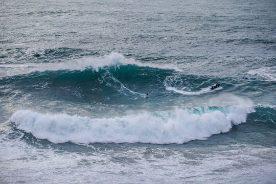 big wave surfer and jet ski in giant wave at Nazar&eacute; Praia do Norte
