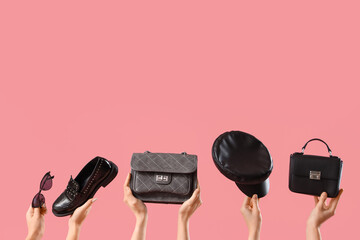 Female hands with stylish women's bags, loafer and hat on pink background
