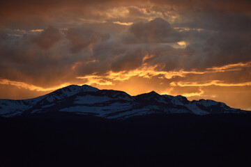 Sun Glowing Through the Clouds at Sunset Over the Rocky Mountains