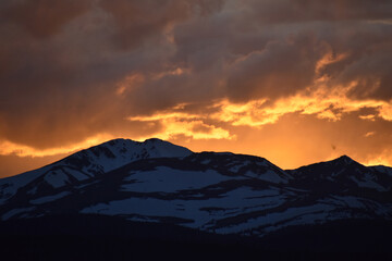 Sun Glowing Through the Clouds at Sunset Over the Rocky Mountains