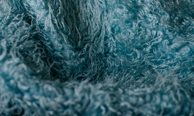 Teal fuzzy blanket sitting in a polka-dotted fabric basket