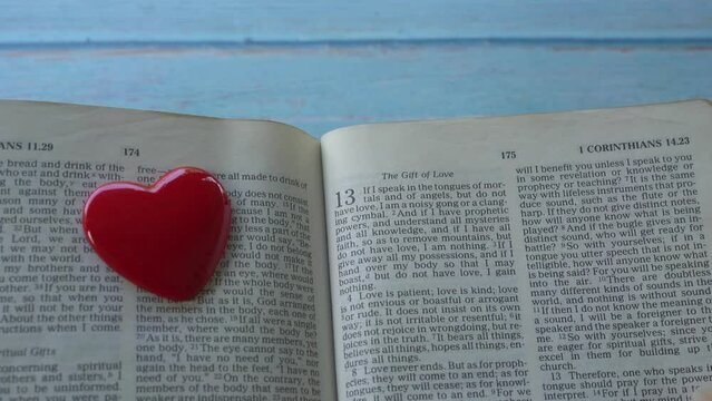 Passage on the gift of love, 1 Corinthians 13 of the new testament, Holy Bible. A red heart next to passage.