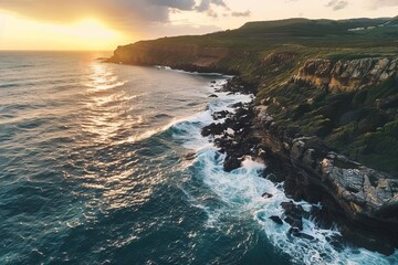 Aerial view of a dramatic coastal landscape with waves crashing against rocky cliffs at sunset