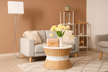Interior of modern living room with flowers and gift box on coffee table in living room