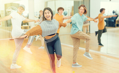 Fototapeta na wymiar Energetic teenagers formed pairs and dancing swing in studio.